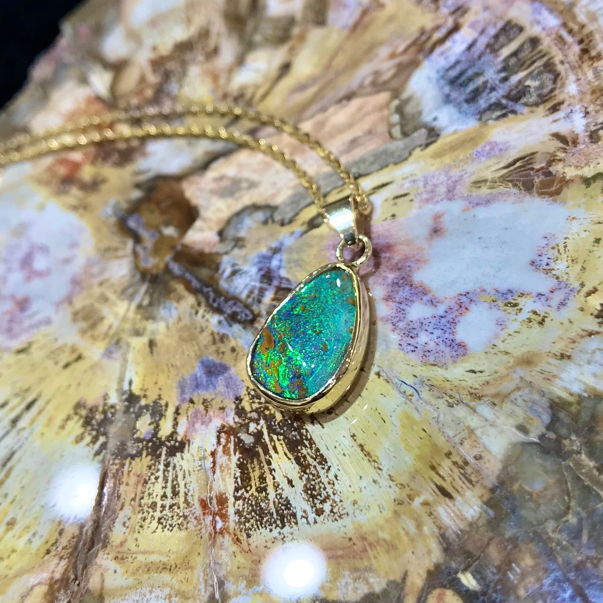 Green and blue Queensland boulder opal pendant in 14k yellow gold on cable chain.