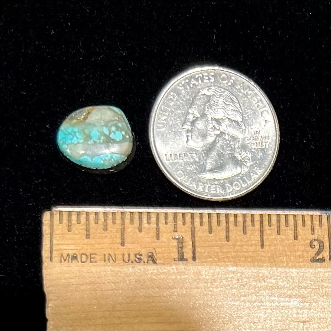A loose, freeform pear shaped cabochon cut Valley Blue turquoise stone from Lander County, Nevada. The stone is blue and green with quartz inclusions.