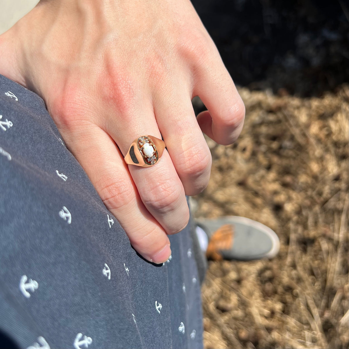 Sunlit hand resting on person's hip wearing a vintage c.1960s opal and diamond women's ring with domed Mid-Century design