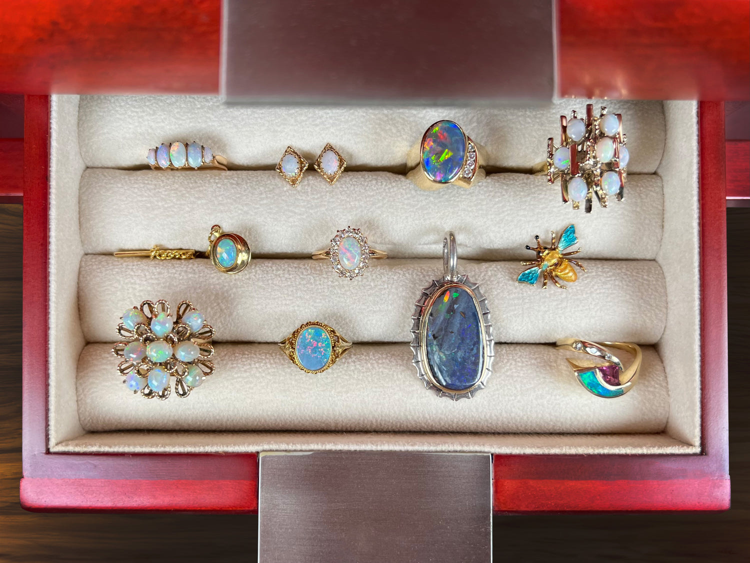 A collection of estate and vintage opal jewelry. Opal rings, earrings, a pendant, and tie-tacks are displayed.