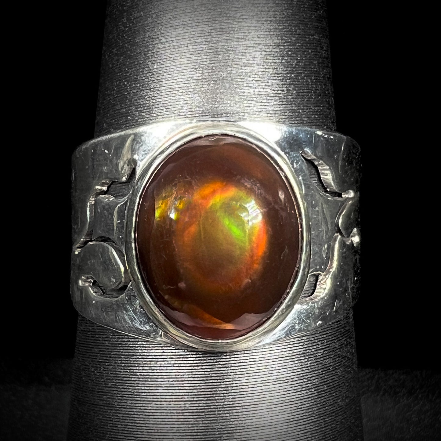 Front close-up of a vintage sterling silver fire agate ring with green and red colors.