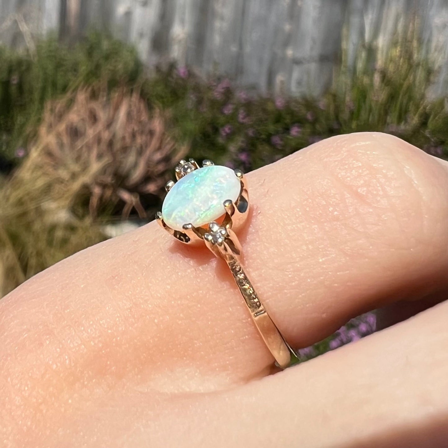 A dainty, 1960's style opal and diamond engagement ring. The ring is prong-set and yellow gold.