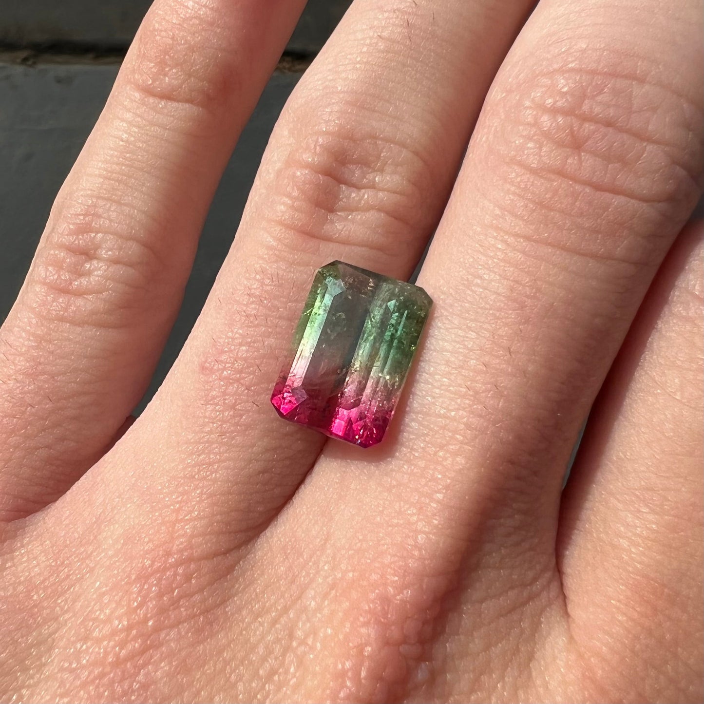 A loose pink and green emerald cut watermelon tourmaline gemstone.