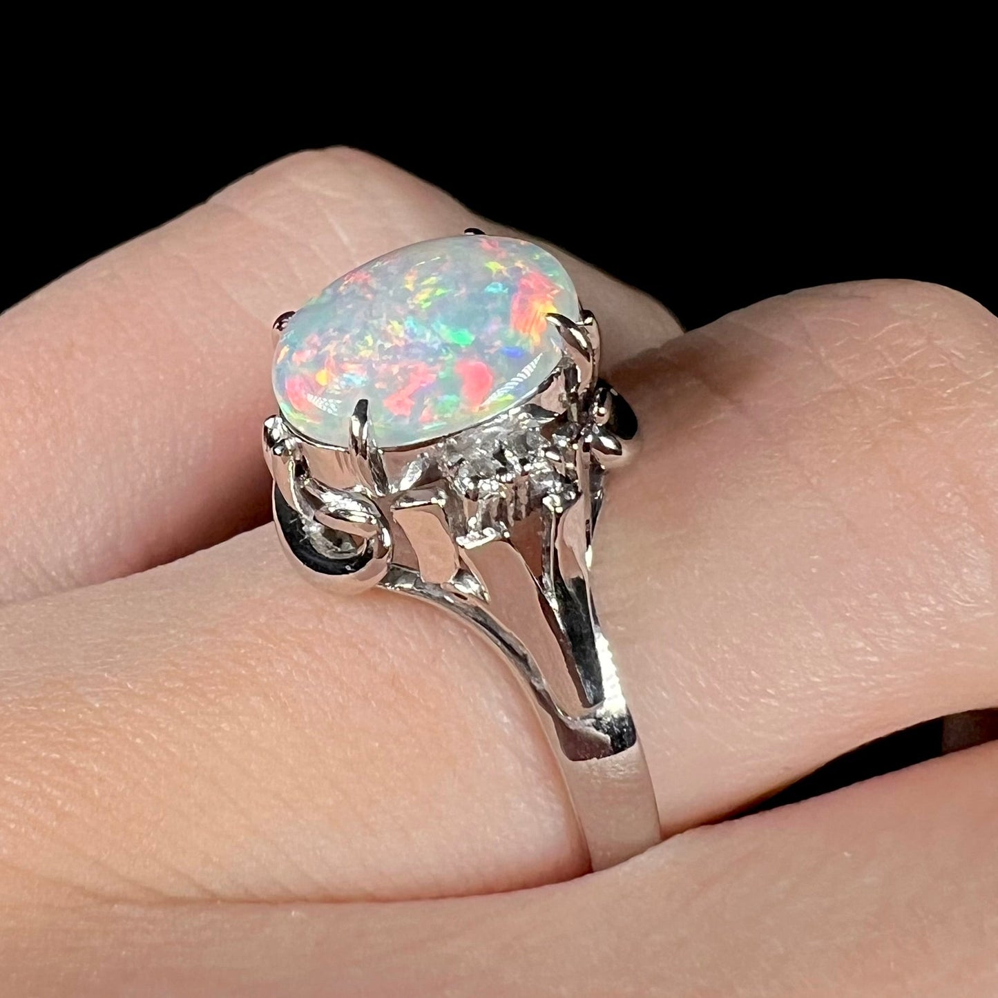 A platinum and diamond ring prong-set with an Australian opal. The opal has pink color play.