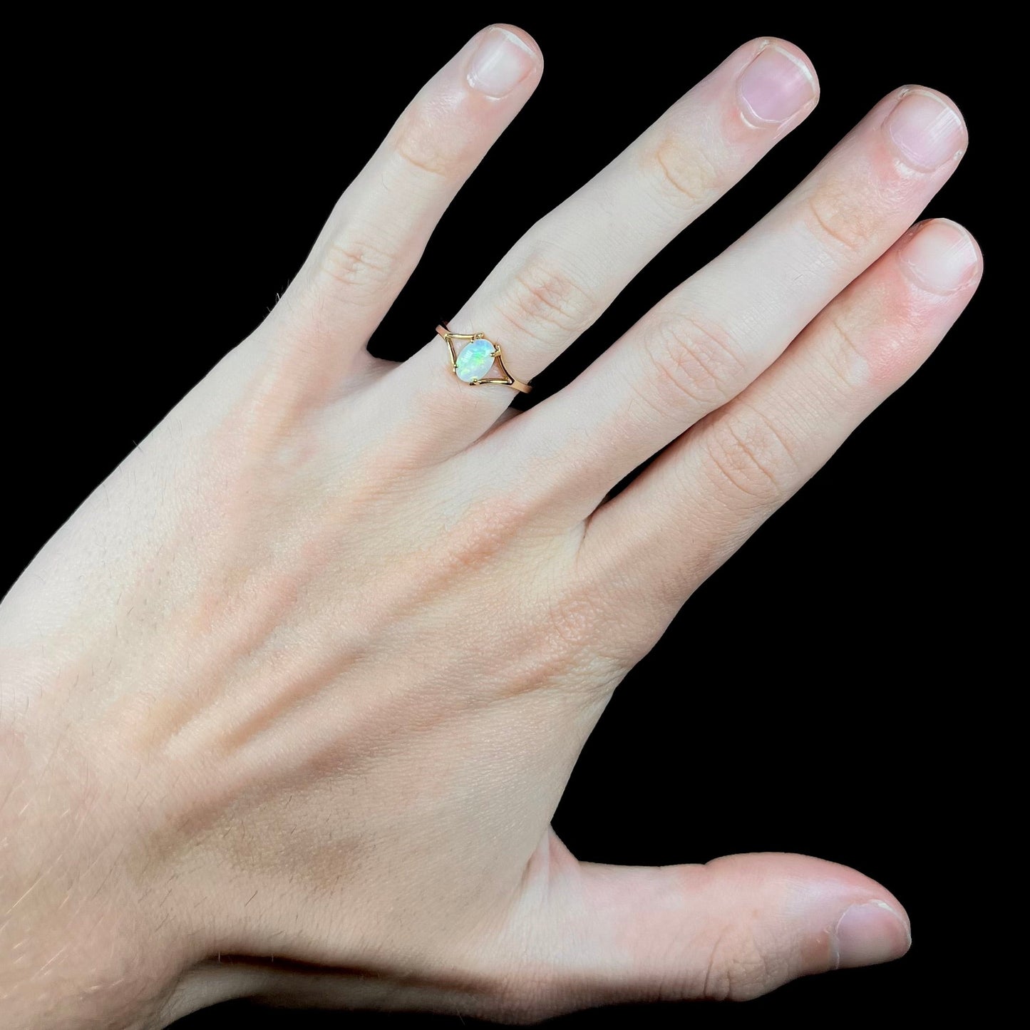 A ladies' simple opal solitaire ring. The ring is yellow gold with a split shank.