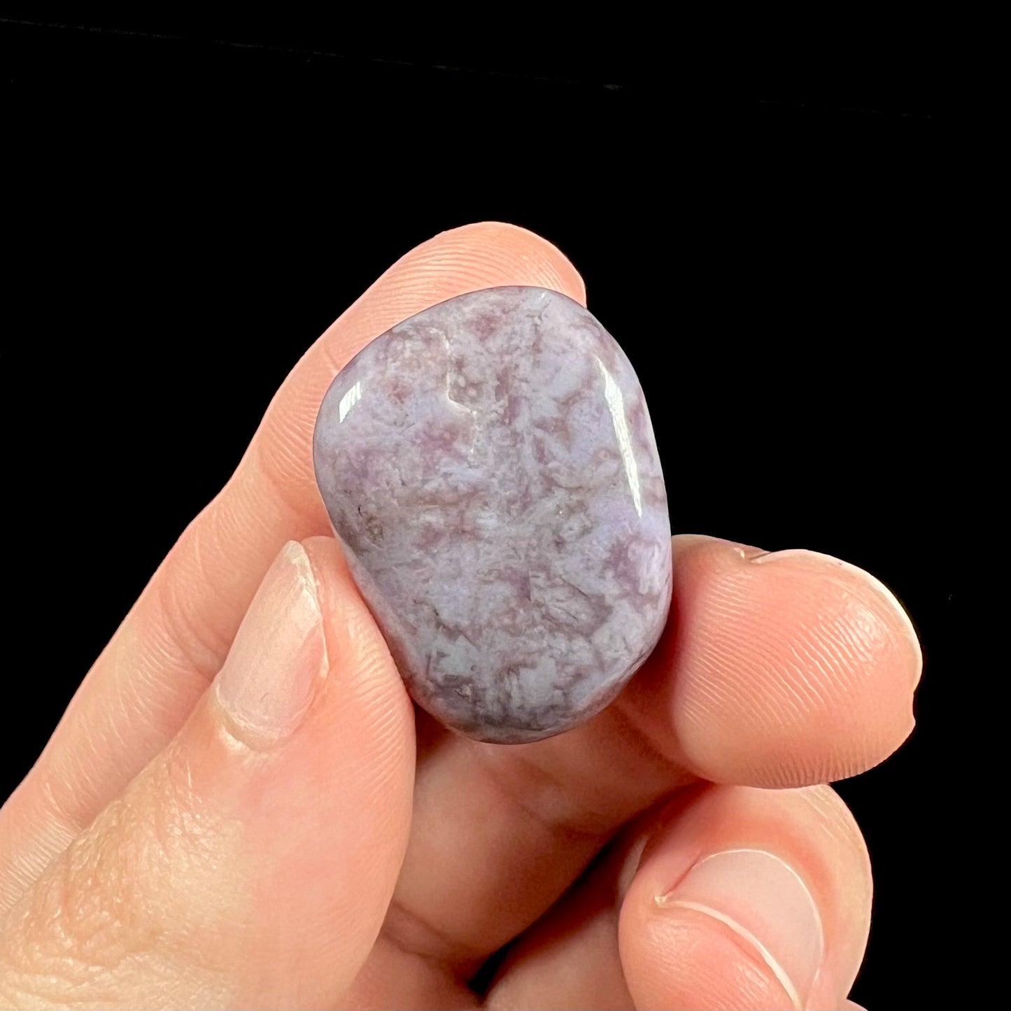 A tumbled Turkish purple jade stone. The material is a "white" lilac purple color.