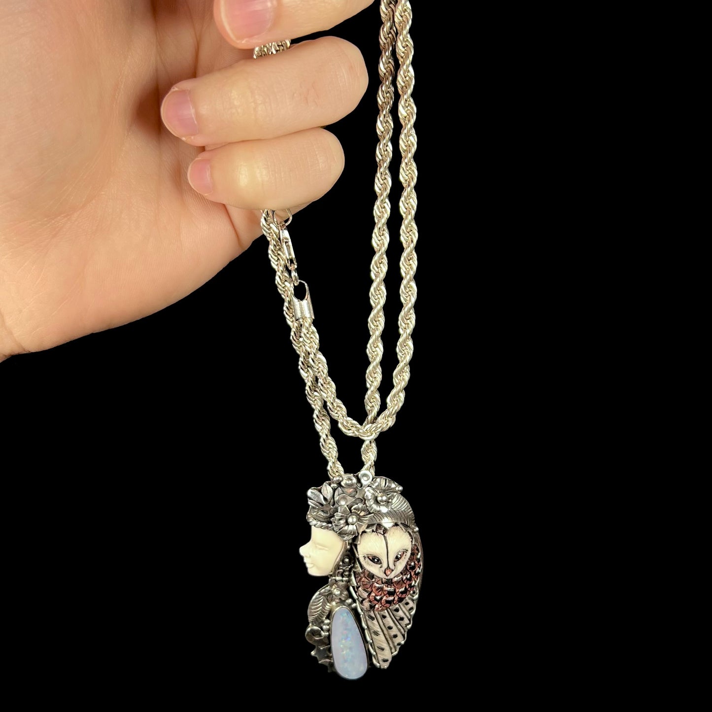 A woman and owl necklace with a nature-inspired motif, made from sterling silver, bone, and an opal doublet.