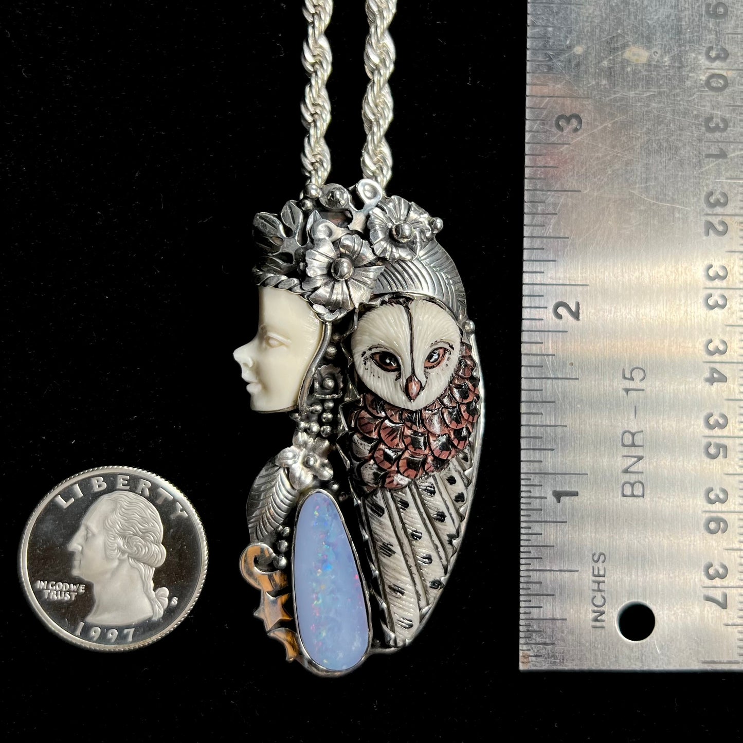 A woman and owl necklace with a nature-inspired motif, made from sterling silver, bone, and an opal doublet.