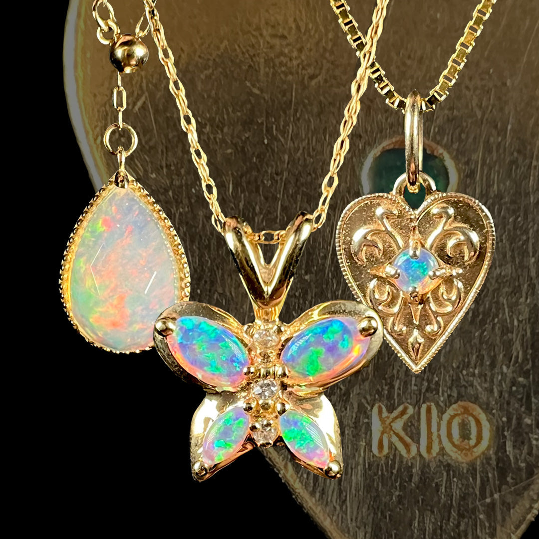 Three 10k gold opal necklaces shown in front of faded gold pendant with "K10" hallmark stamp in focus.