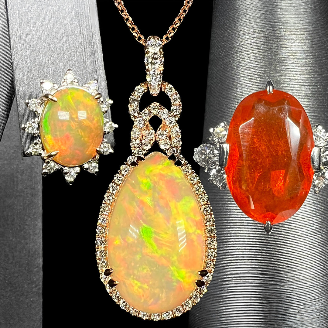 Three pieces of fire opal jewelry; from left to right, an Ethiopian fire opal and diamond earring, a pear shaped Ethiopian opal necklace, and a Mexican fire opal and diamond ring.