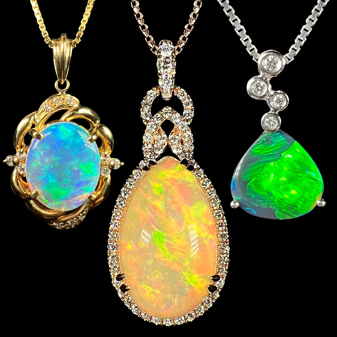 Three gold opal necklaces shown against a black background; from left to right, a yellow gold crystal opal pendant, a pear-shaped Ethiopian opal pendant in rose gold, and a white gold black opal pendant.