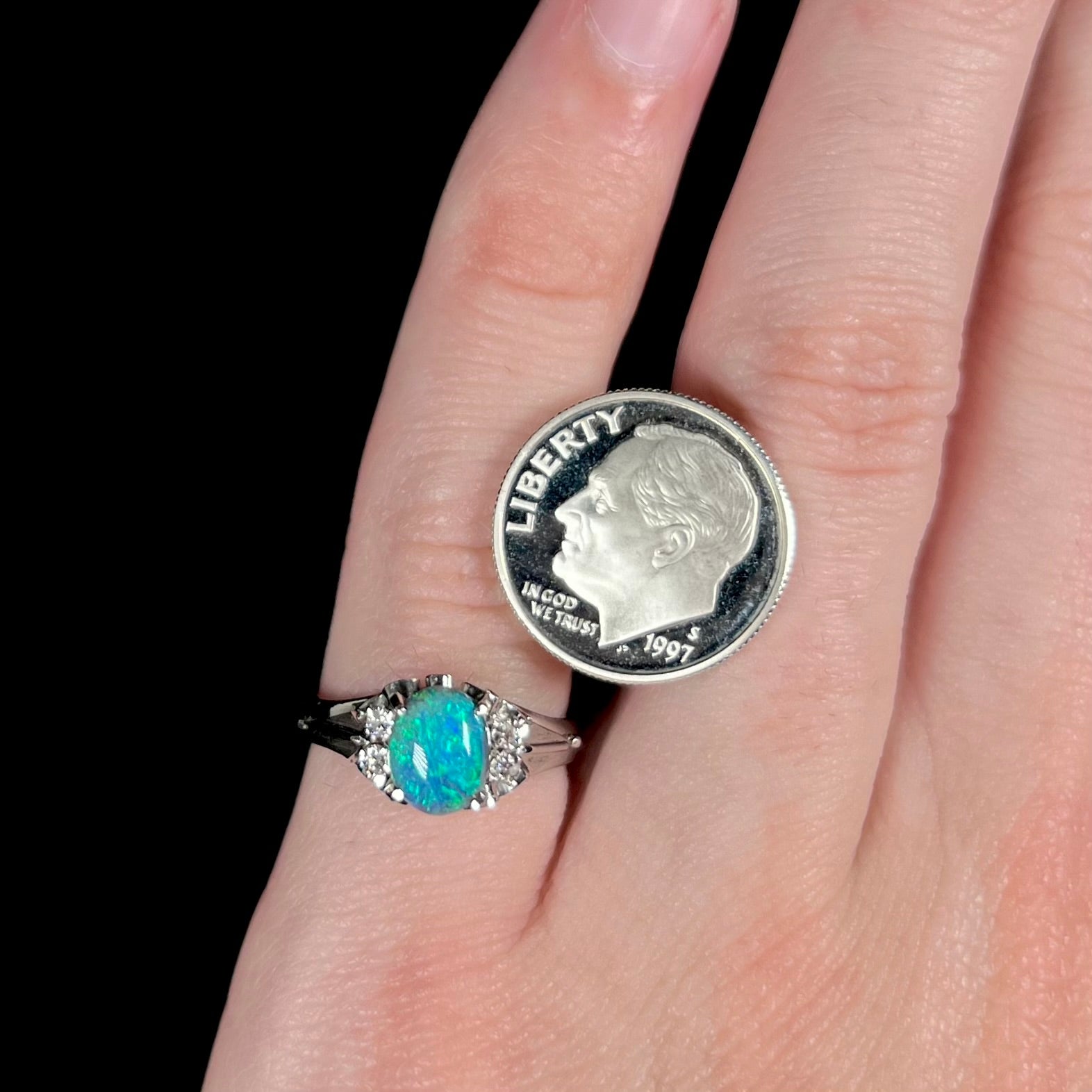 A 0.89ct black opal platinum ring worn next to a US dime coin for scale.