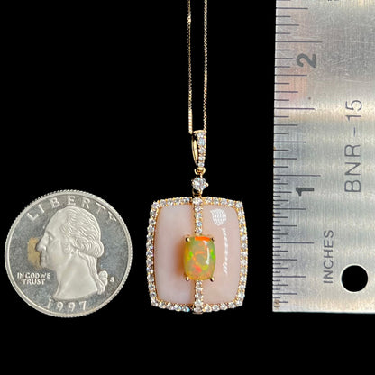 A 1.4 inch-long women's Ethiopian fire opal and diamond pendant shown next to a quarter coin and ruler for scale.