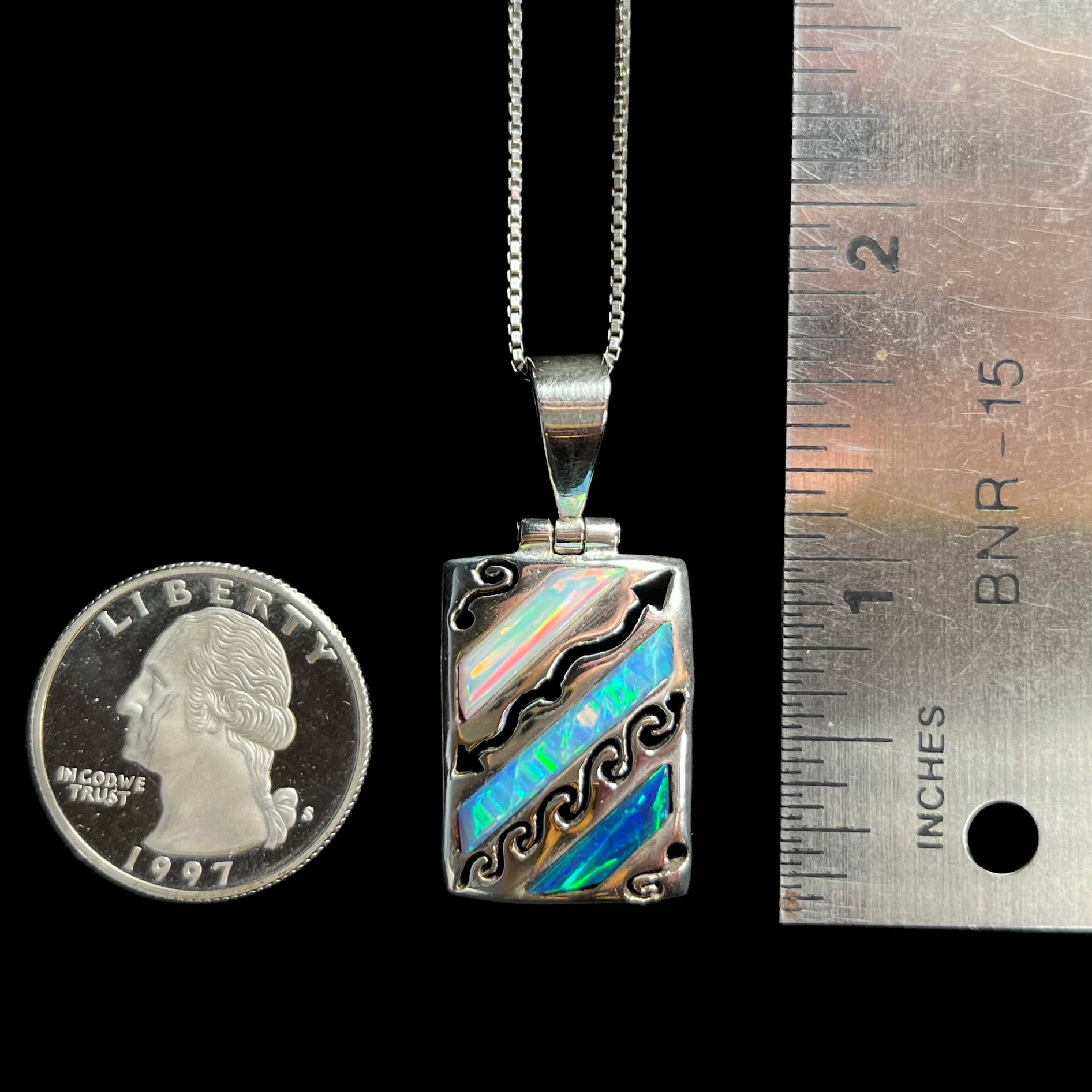 A 1.5 inch long men's 950 silver lab-created opal necklace, shown next to a ruler and quarter coin.