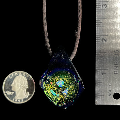 A 1.7 inch-long faceted glass pendant with a trillion cut opal inside, shown next to a ruler and quarter coin for scale.