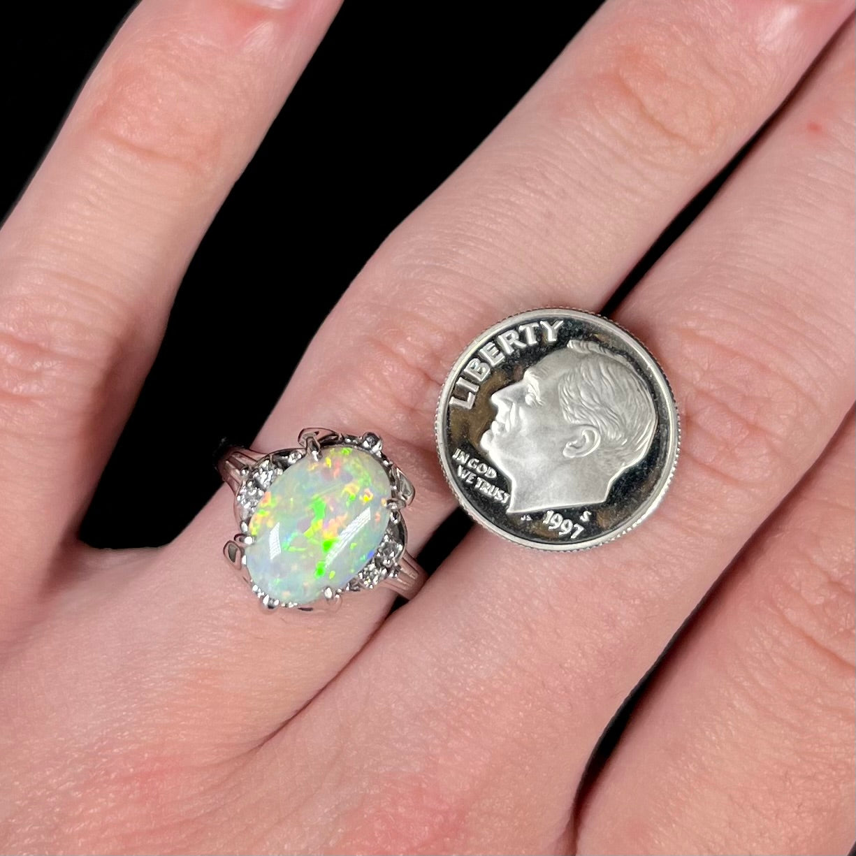 A Japanese-style platinum ring mounted with a Coober Pedy opal and diamond accents.