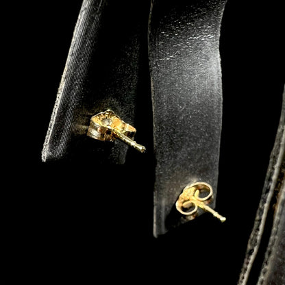 10k yellow gold pushback stud earring backs shown from back side on earring display against black background.