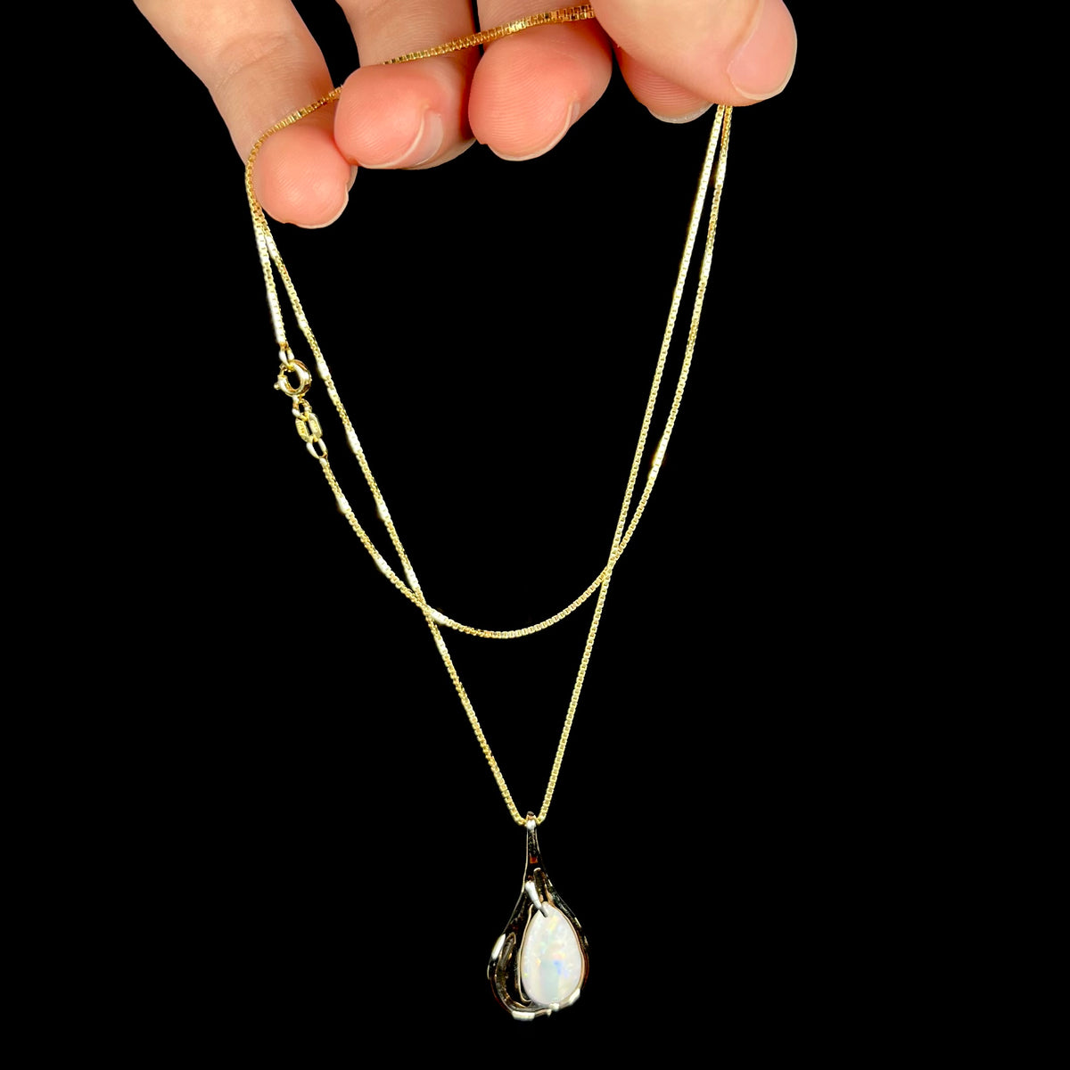 Hand dangling 14k gold Modernist-style opal necklace from its chain