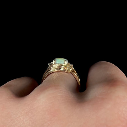 Side profile gallery view of 14k gold Modernist design opal and diamond ring, worn on finger