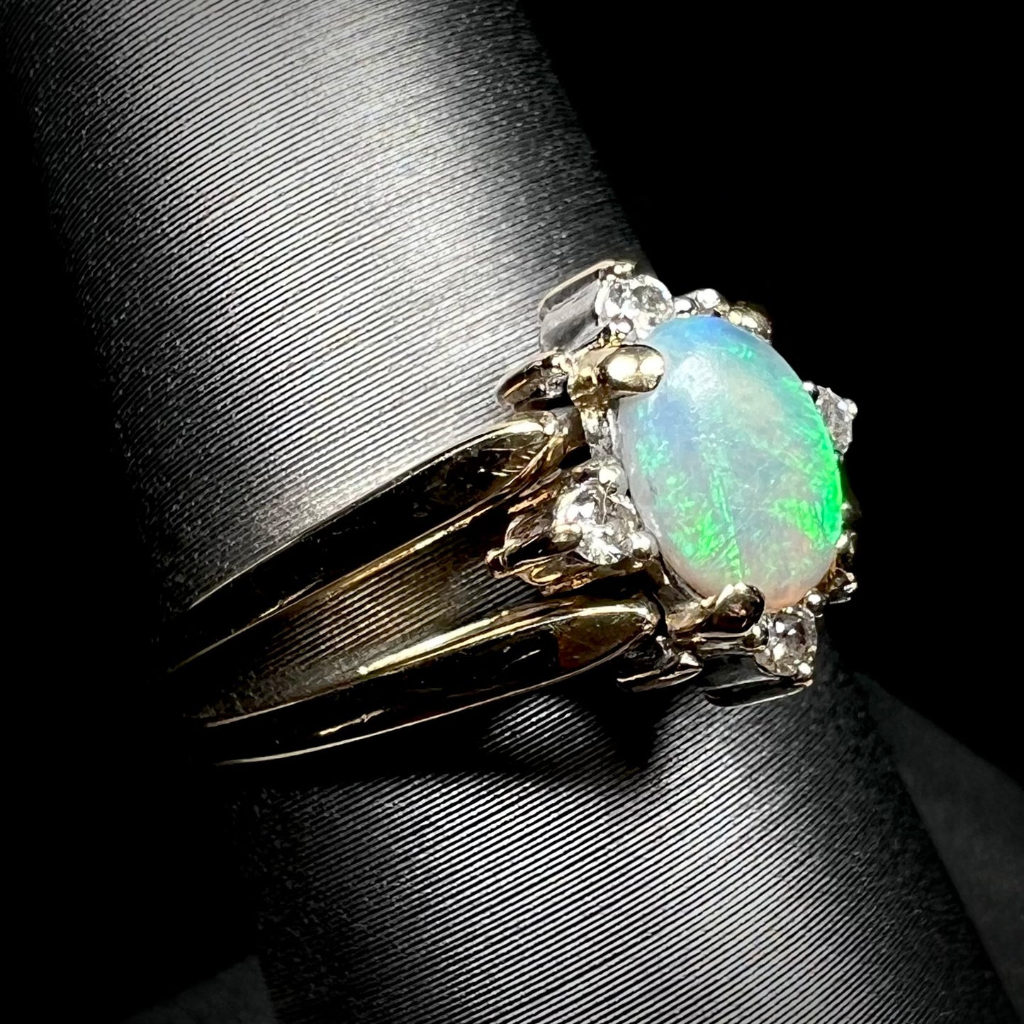 14k gold opal and diamond flip ring shown close-up from angle on ring display