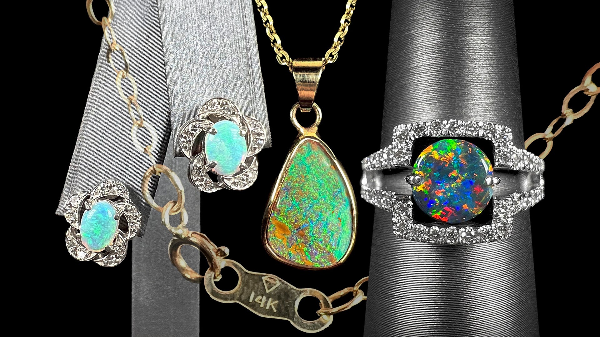 14k gold opal jewelry shown with gold chain stamped with "14K" hallmark. Pieces shown include white gold flower earrings, yellow gold boulder opal necklace, and black opal ring.