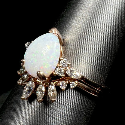 14k rose gold pear shaped opal and moissanite engagement and wedding ring set on display