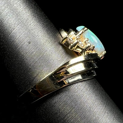 Side view of 14k yellow gold opal ring on ring display, focused on one side of ring's shank