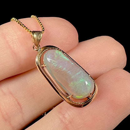 Angled macro shot of an 18k gold opal necklace, revealing very subtle green flashes.