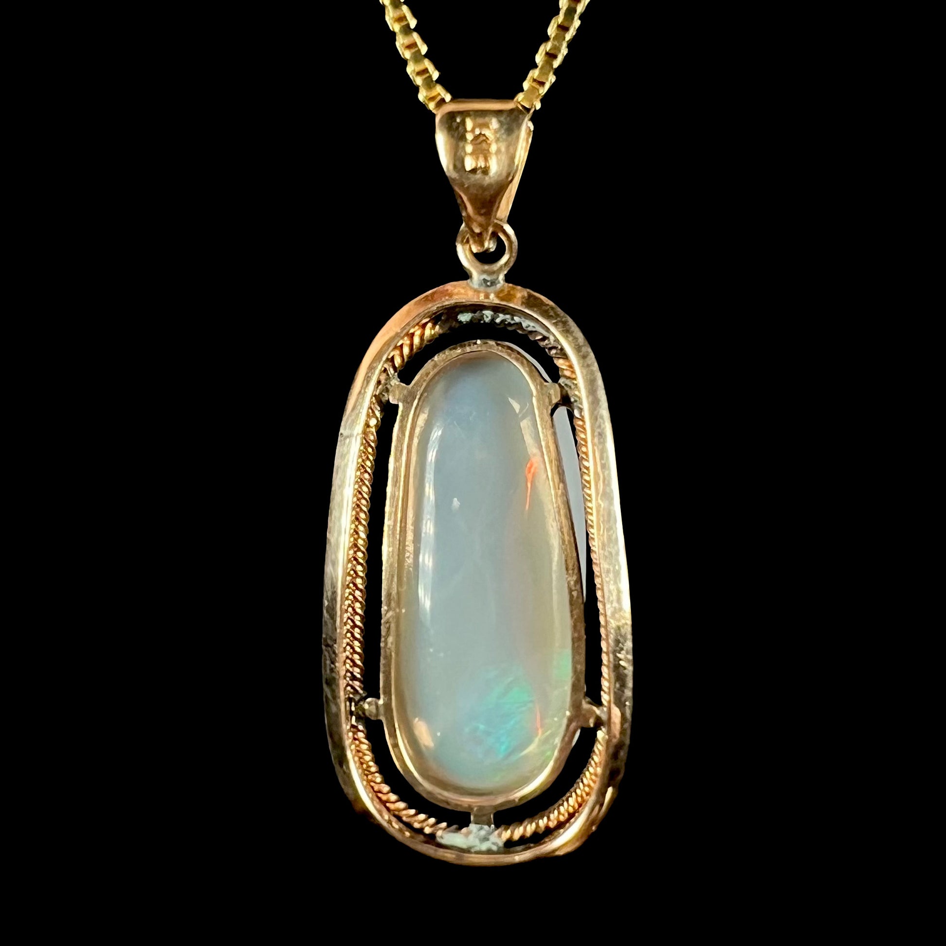 Back view of an 18k gold opal necklace, showing the open gold frame and the opal’s translucent body tone.