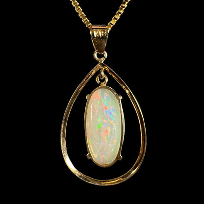 Back view of an 18k gold opal necklace, showing the open basket mounting and ‘K18’ stamp on the bail.