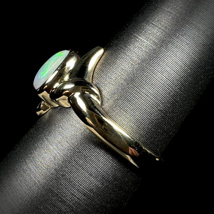 The side view of an 18k gold opal solitaire ring.