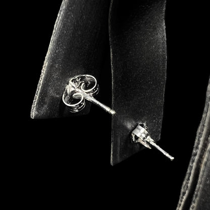Back side of 18k white gold opal earrings shown on earring display; push-back posts and butterfly backs are in focus, opals are not visible.