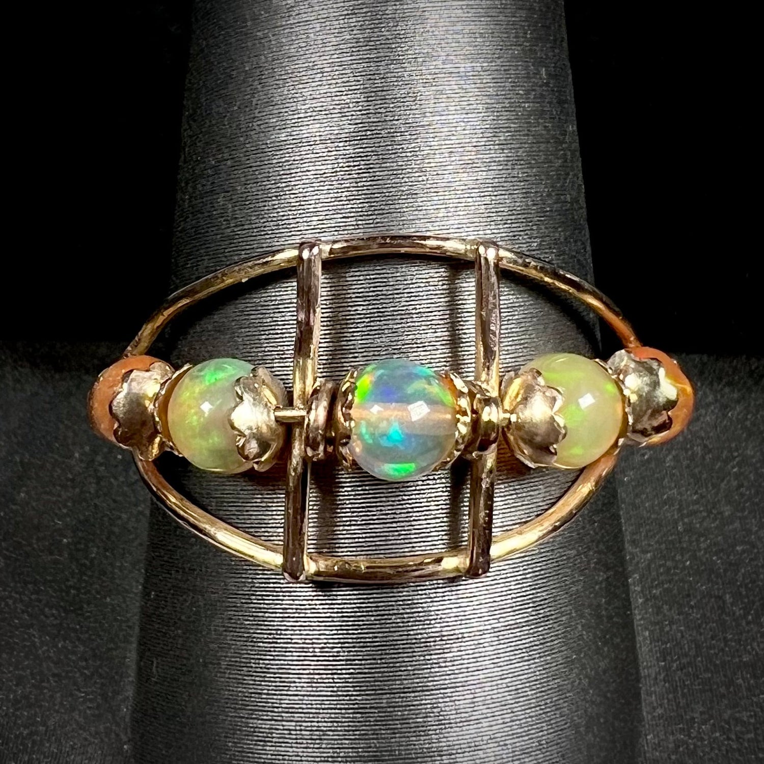 An 18 karat yellow gold ring set with five natural fire opal beads that spin along the ring.