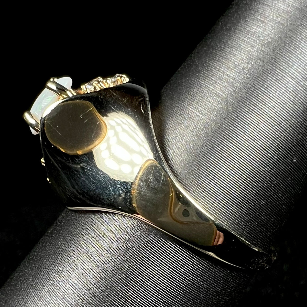 Side view of a 1960s Mid-Century era 14k gold opal ring with polished dome design, shown on ring display