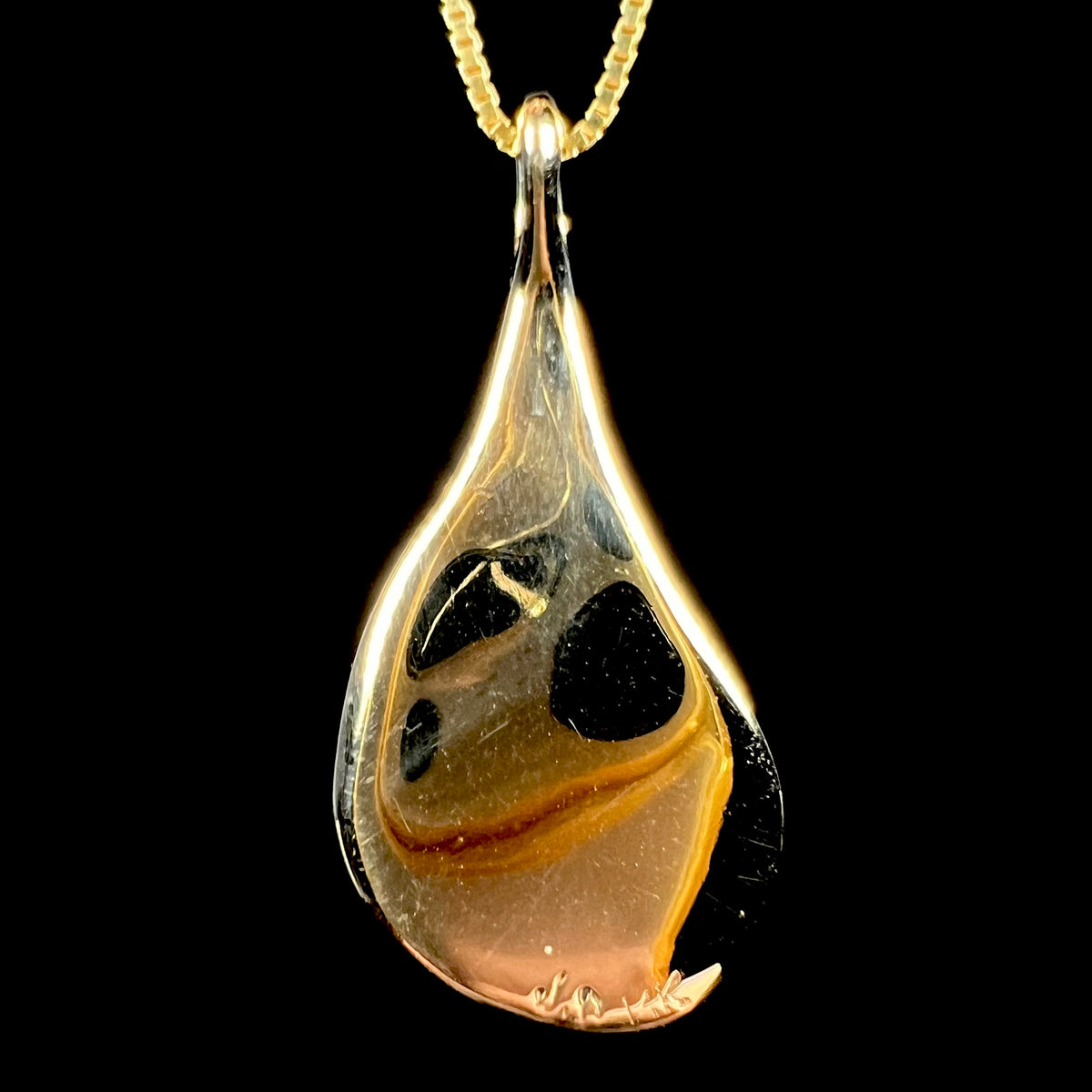 Back side of c.1980s era 14k gold pendant.  The hallmark stamps "J.D" and "14K" are visible at the bottom of the pendant.