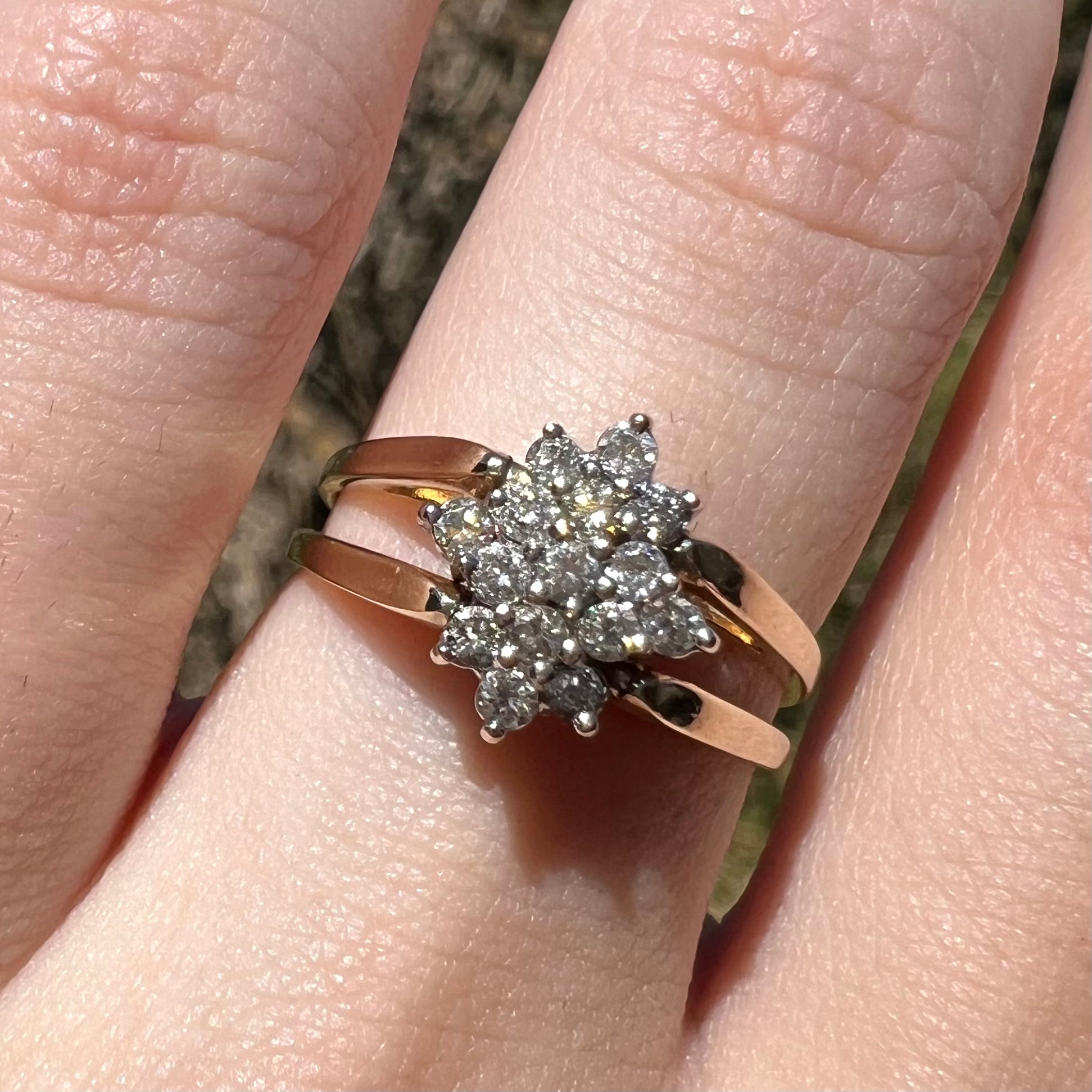 1980s era reversible diamond cluster ring in 14k gold shown close-up on finger under sunlight