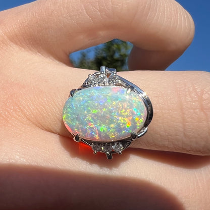 A platinum ring set with a 2.54ct Coober Pedy semi-crystal opal and diamond accents.