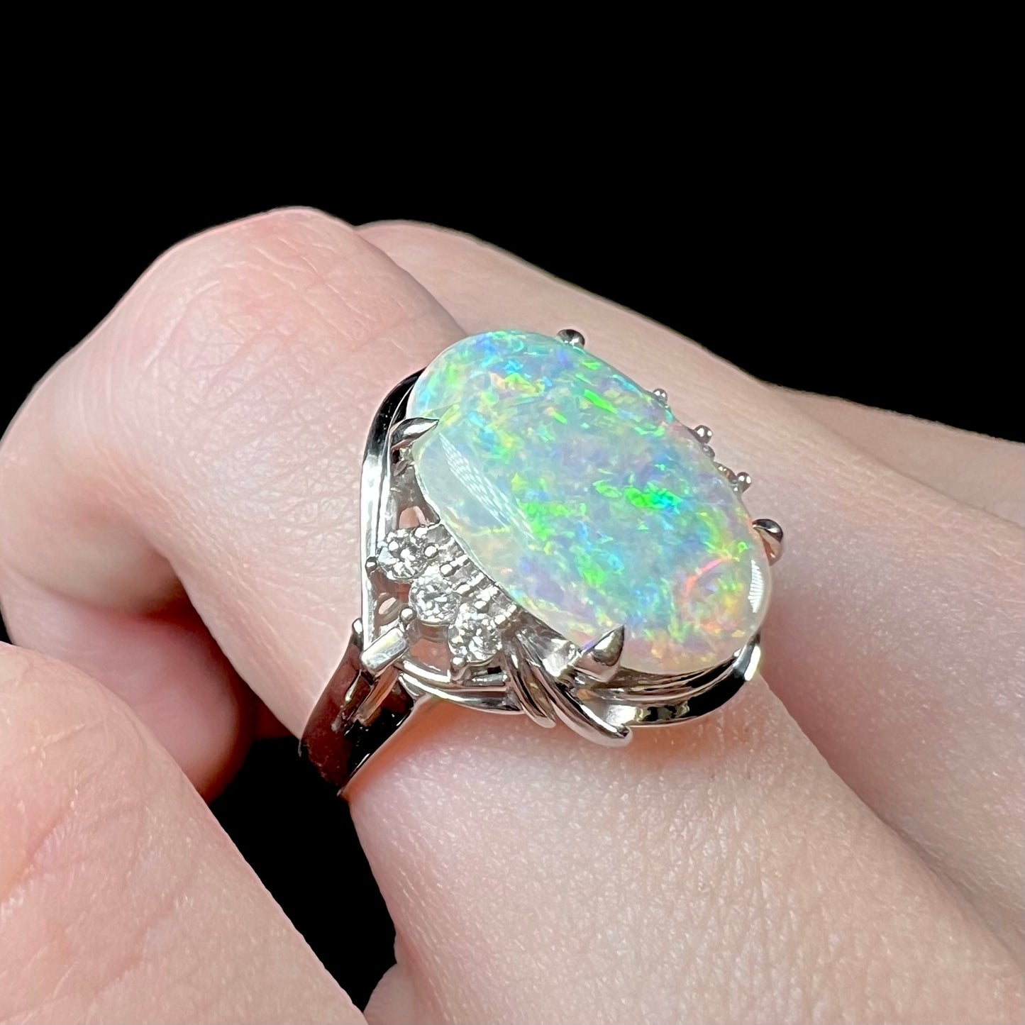 A platinum ring set with a 2.54ct Coober Pedy semi-crystal opal and diamond accents.