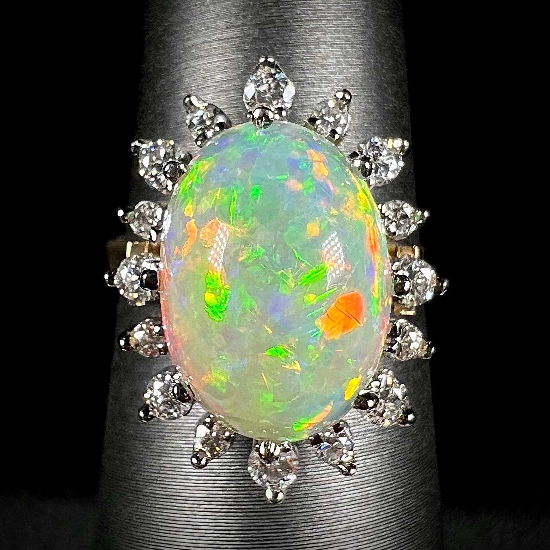 A 4.30ct Lightning Ridge crystal fire opal engagement ring set with a diamond halo.  The opal displays rolling red flashes with static green.