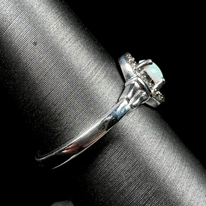 Side view of sterling silver ring set with white opal and smoky quartz accents, shown on ring display; the ring's shank is the primary focus