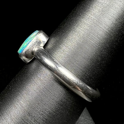 Side view of .999 pure silver opal ring on ring display, focused on ring's handmade shank 