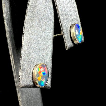 9k gold opal triplet stud earrings with multicolor fire shown on earring display