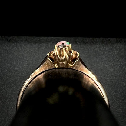Side gallery profile view of an antique 9k gold Victorian opal ring shown close-up on a ring display.
