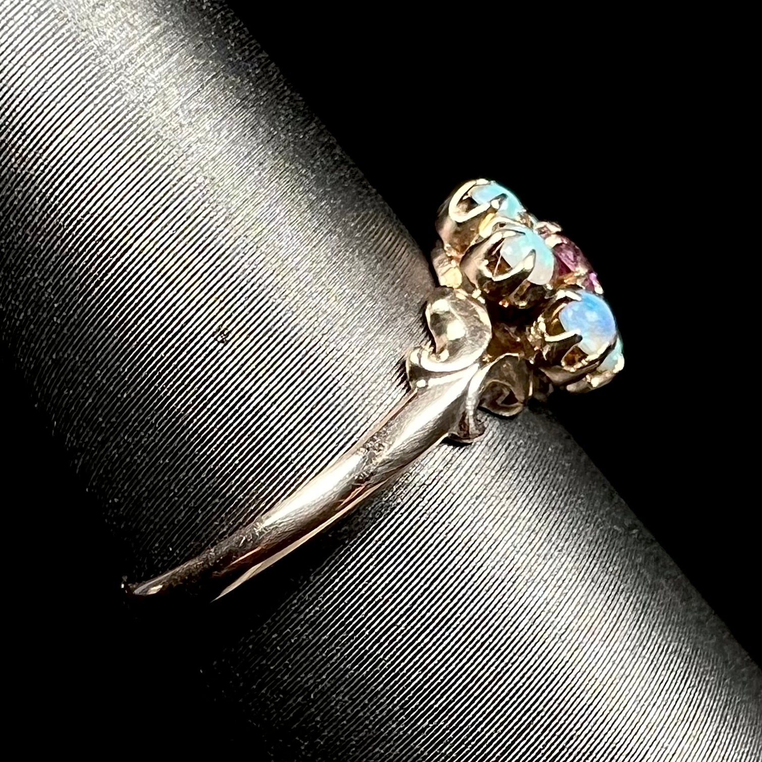 Antique 9k gold opal ring shown on ring display from side view, focused on ring's dainty shank