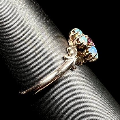 Antique 9k gold opal ring shown on ring display from side view, focused on ring's dainty shank