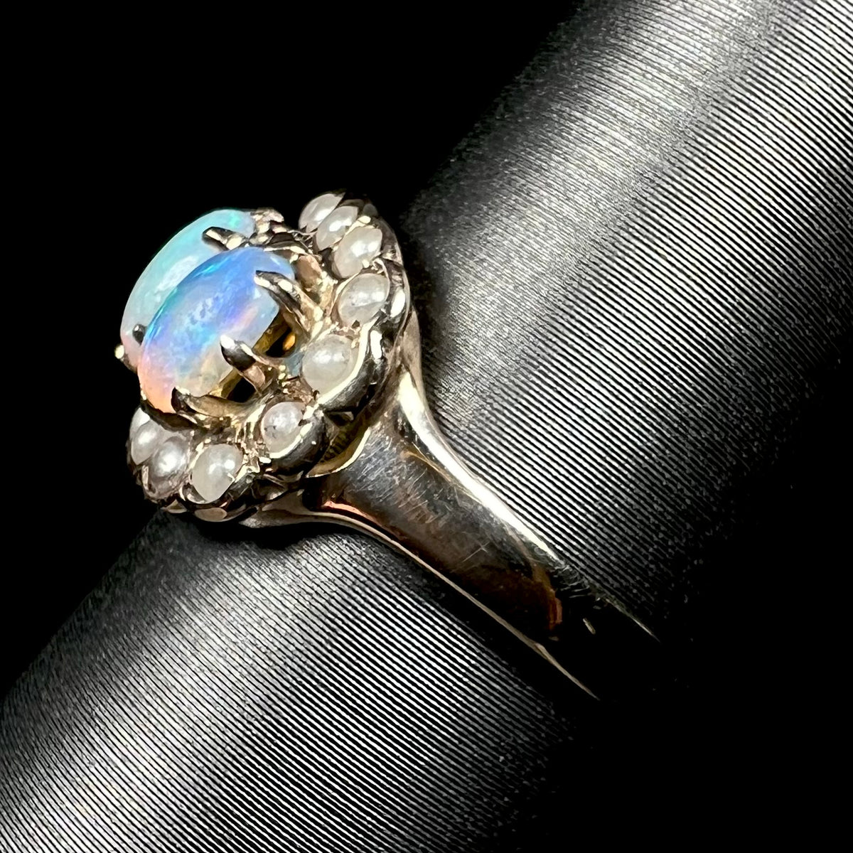 Side view of antique gold opal and pearl ring on display