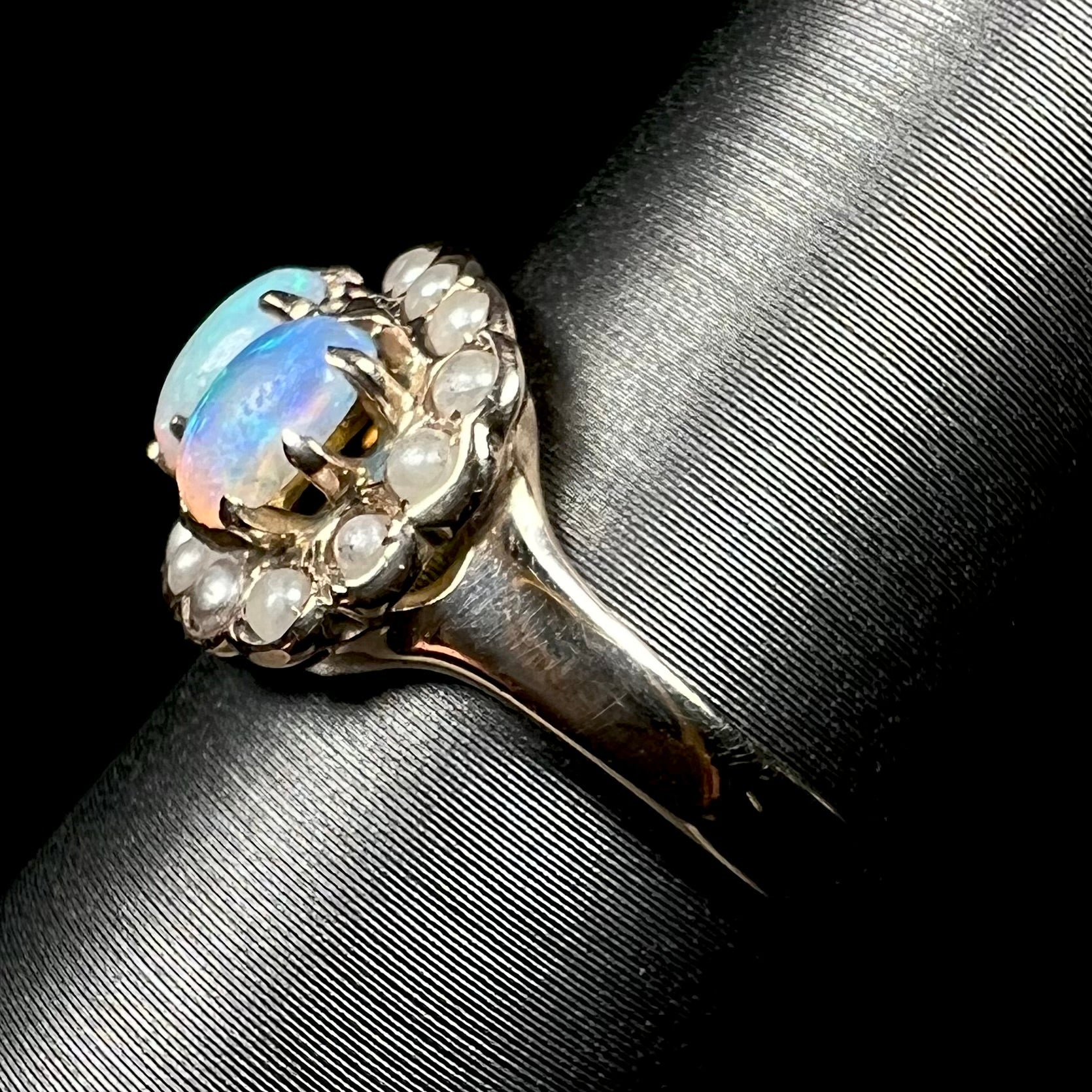 Side view of antique gold opal and pearl ring on display