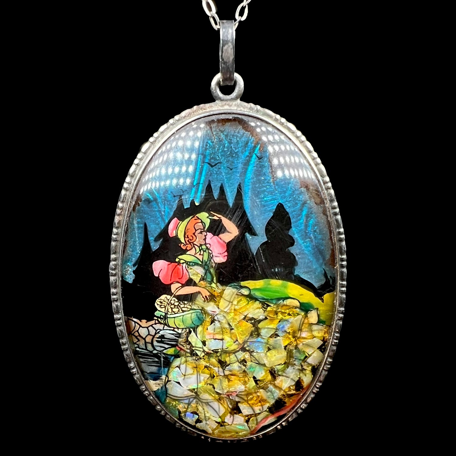 Front of antique painted butterfly wing and crushed opal pendant in silver depicting a woman by England's Shipton and Company.