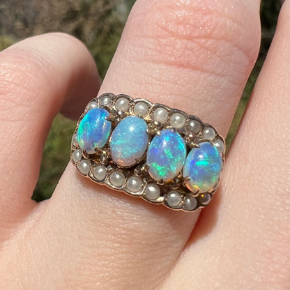 Macro close-up of antique Victorian crystal opal and seed pearl-accented ring, worn on finger in natural light
