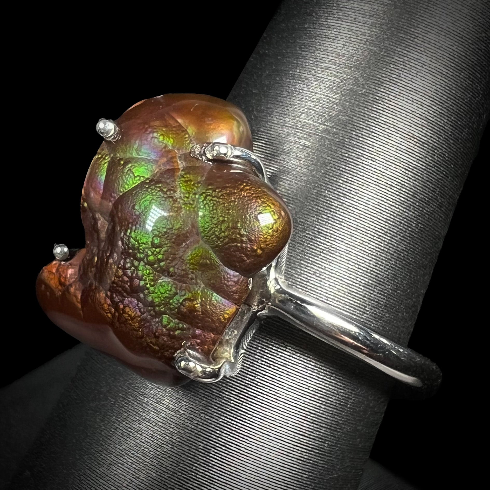 Angled view of the Arizona fire agate ring showing green and purple iridescence.